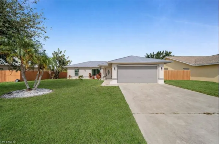 Single story home with concrete driveway and an attached garage