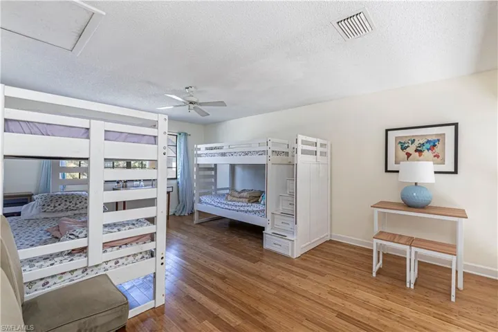 Bedroom featuring hardwood / wood-style floors, a textured ceiling, and a ceiling fan