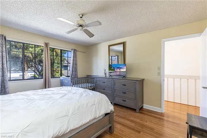 Bedroom featuring light wood-style floors, a textured ceiling, and a ceiling fan