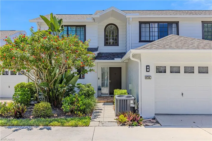 Traditional home featuring a shingled roof and an attached garage
