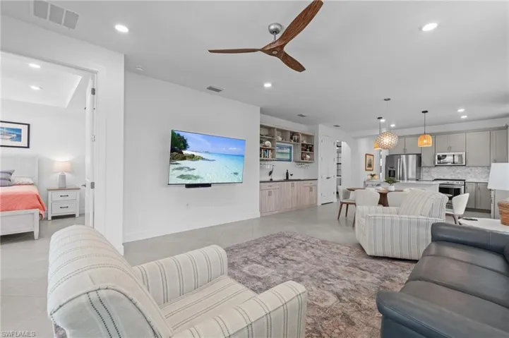 Living area with recessed lighting, light tile patterned floors, and a ceiling fan