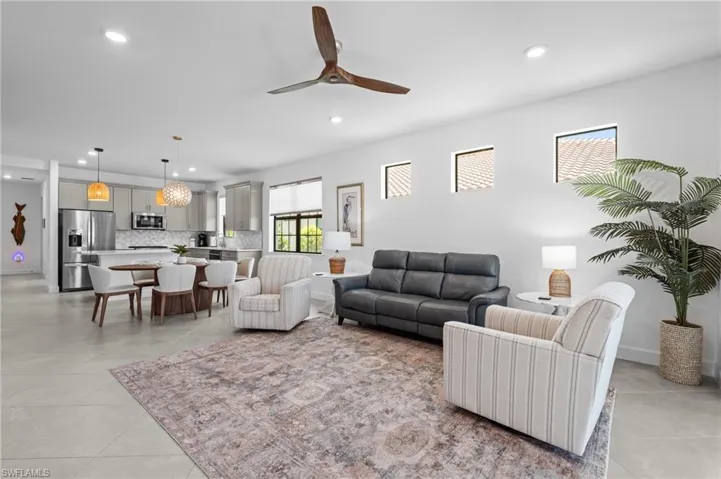 Living room with recessed lighting, ceiling fan, and light tile patterned flooring