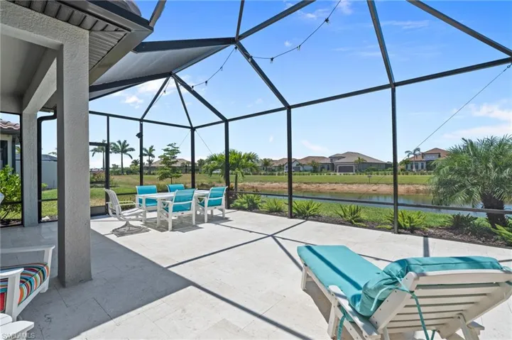View of patio / terrace with glass enclosure, a water view, outdoor dining area, and a residential view