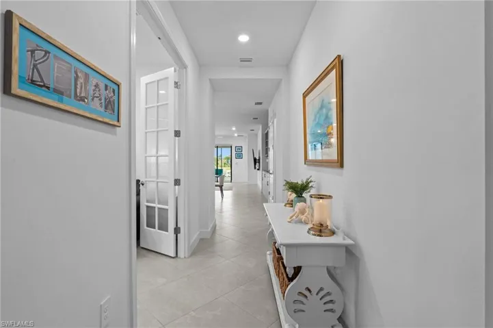 Corridor with light tile patterned flooring, baseboards, and recessed lighting