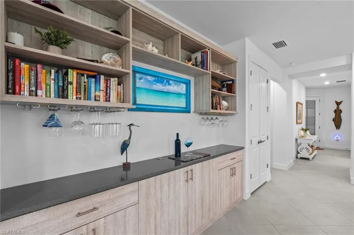 Indoor bar with light tile patterned floors, baseboards, and recessed lighting