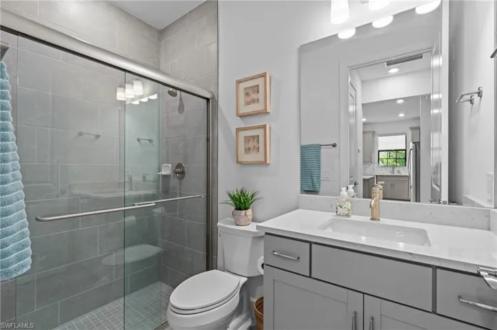 Full bath featuring a shower stall, toilet, and vanity
