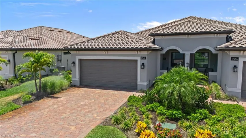 Mediterranean / spanish-style house with a tile roof, an attached garage, stucco siding, and decorative driveway