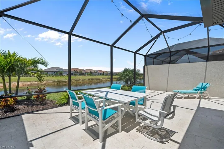 View of patio / terrace with a water view, outdoor dining area, and a lanai