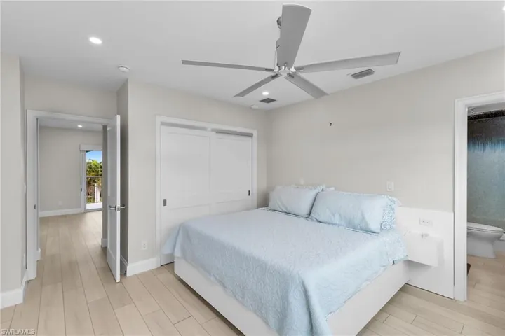 Bedroom featuring wood finish floors, a closet, ceiling fan, recessed lighting, and ensuite bath