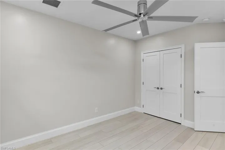 Unfurnished bedroom featuring light wood-style floors, recessed lighting, ceiling fan, and a closet