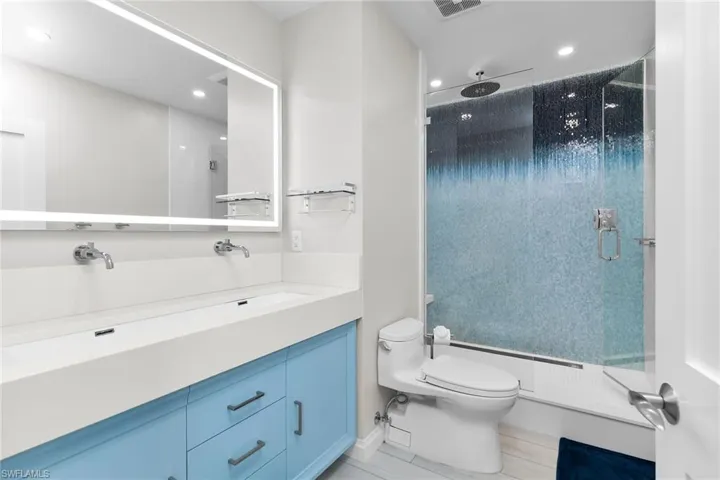 Full bathroom with a shower stall, vanity, and recessed lighting