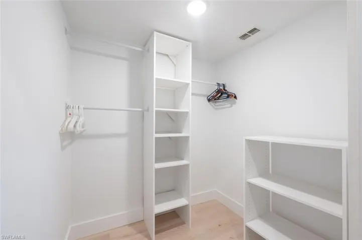 Primary Bedroom Walk in closet with light wood-type flooring
