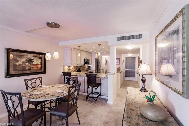 Dining space with ornamental molding and baseboards