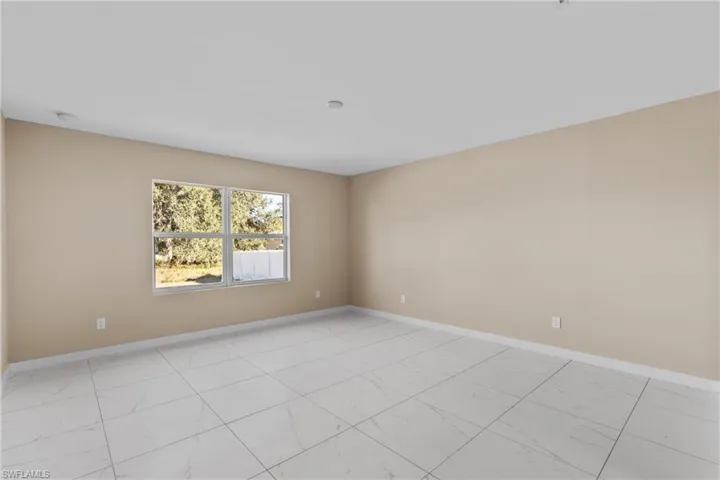 Unfurnished room featuring baseboards and light marble finish floors