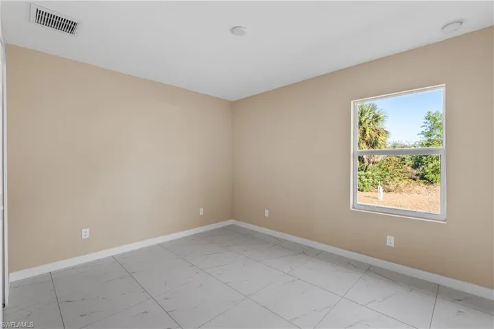 Spare room featuring baseboards and light marble finish flooring