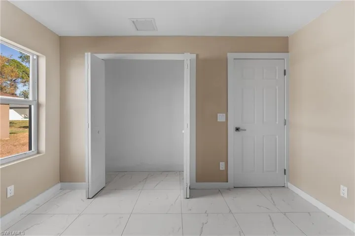 Unfurnished bedroom with a closet and light marble finish flooring