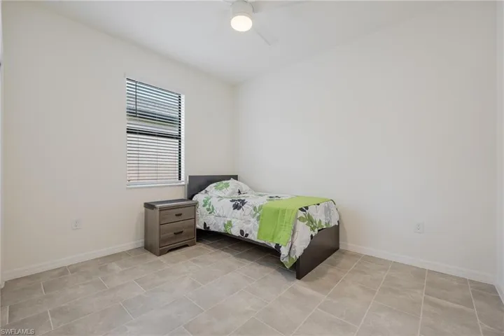 Bedroom featuring ceiling fan and light tile flooring