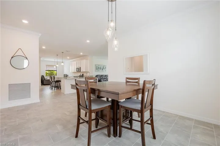 Tiled dining area featuring crown molding