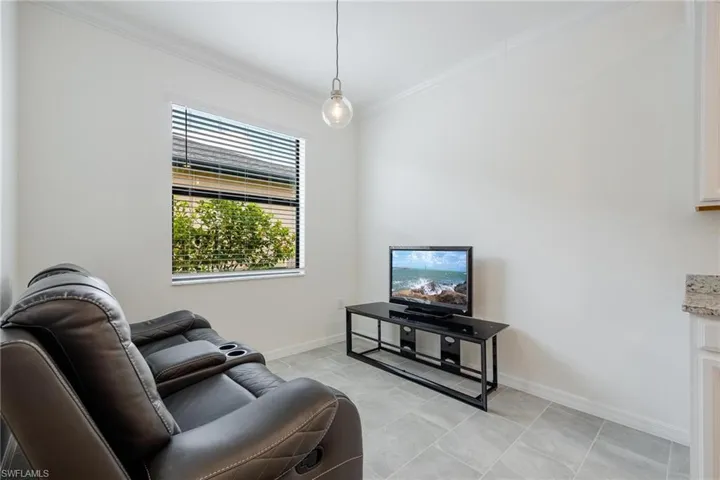 Tiled living room featuring crown molding