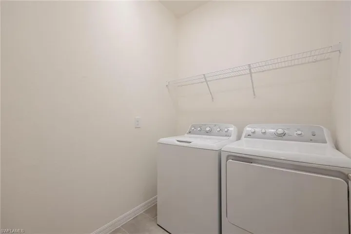 Laundry room featuring separate washer and dryer and light tile flooring