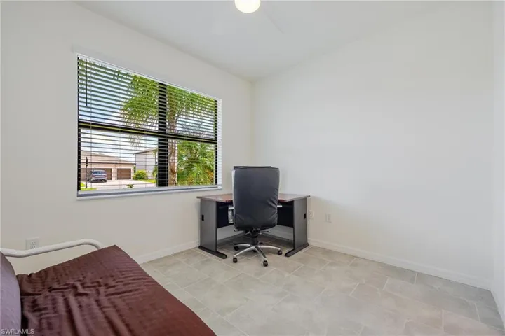 Office with ceiling fan and light tile flooring