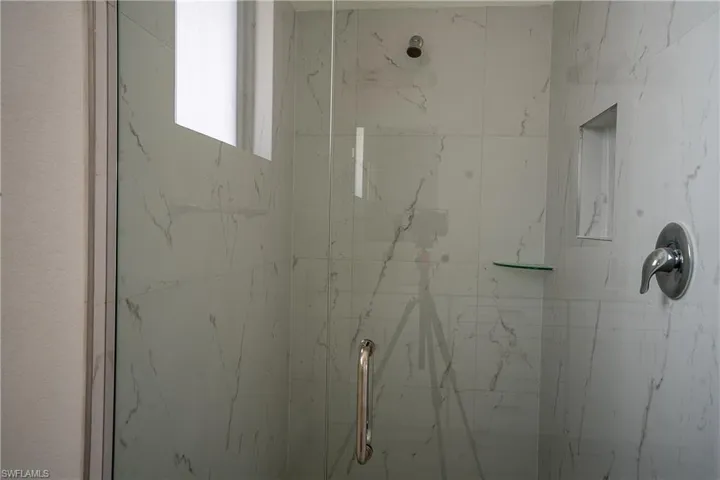 Shower enclosure with clear glass paneling and a polished chrome handle