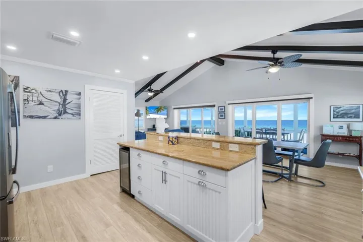 Kitchen featuring white cabinets, a center island, light wood finished floors, healthy amount of natural light, and recessed lighting