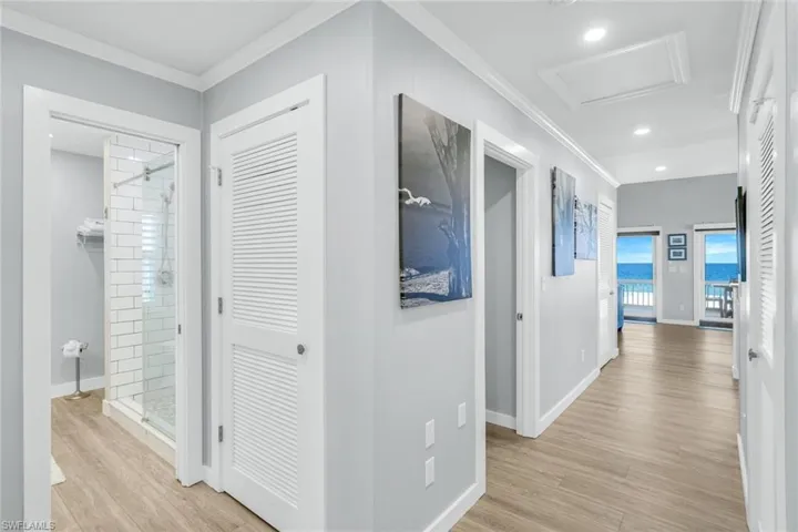 Hall featuring light wood finished floors, attic access, ornamental molding, and recessed lighting