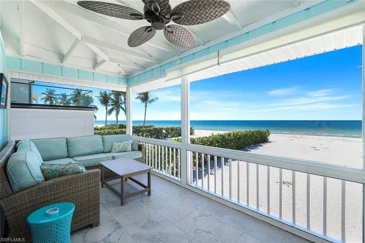 Sunroom / solarium with view of water and beach and plenty of natural light