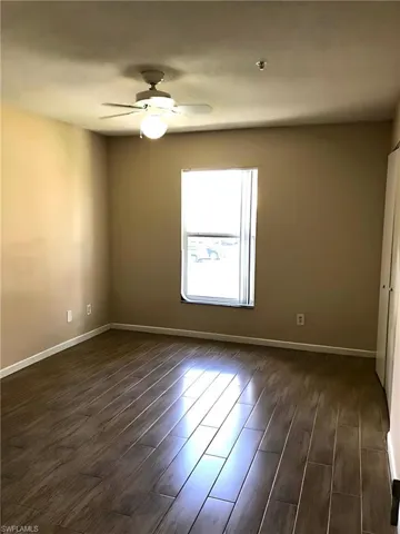 Spare room featuring dark wood finished floors and a ceiling fan