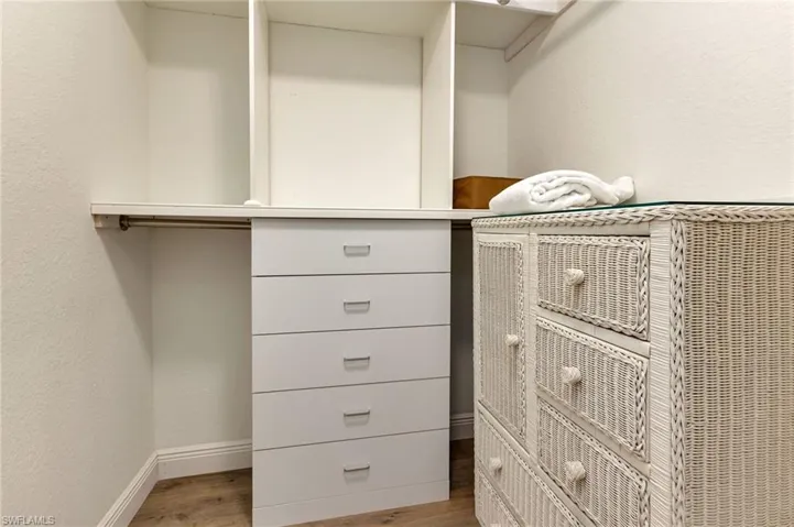 Walk in closet with light wood-type flooring