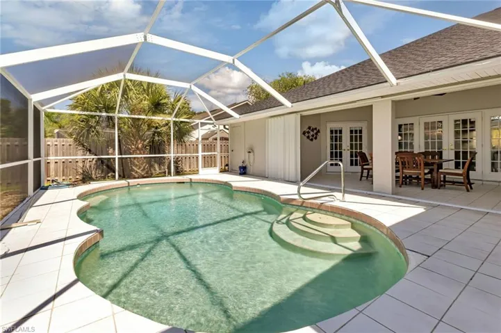 View of swimming pool featuring a patio, french doors, and glass enclosure