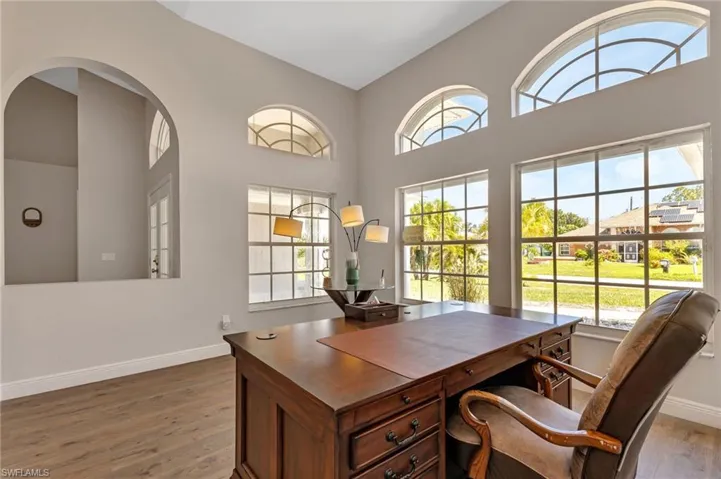 Home office featuring hardwood / wood-style floors and high vaulted ceiling