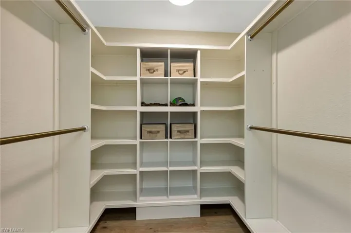 Walk in closet with wood-type flooring