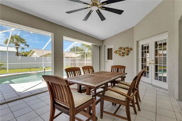 Tiled dining room featuring french doors, ceiling fan, and vaulted ceiling