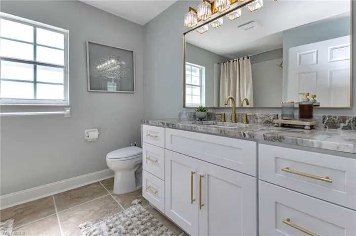 Bathroom with vanity, tile patterned floors, and toilet