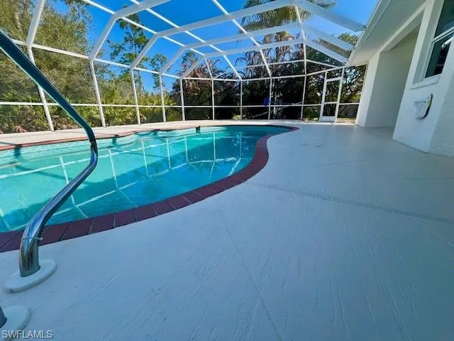 Swimming pool featuring a sunroom, a patio, and enclosure