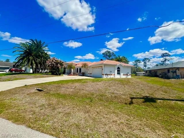 Single story home with a garage, a front yard, and concrete driveway