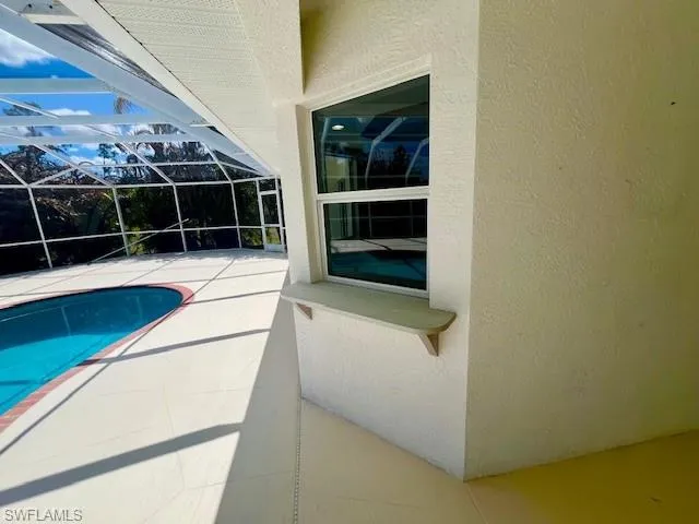 Outdoor pool featuring a lanai, a patio area, and a sunroom