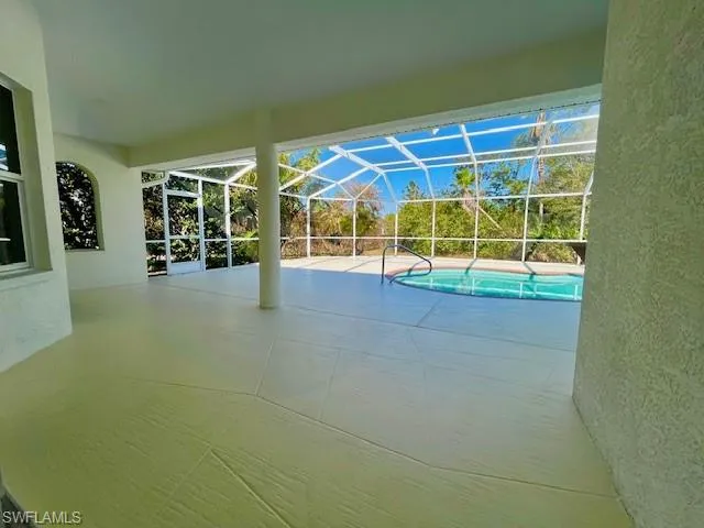 Swimming pool with a patio area, a sunroom, and a lanai