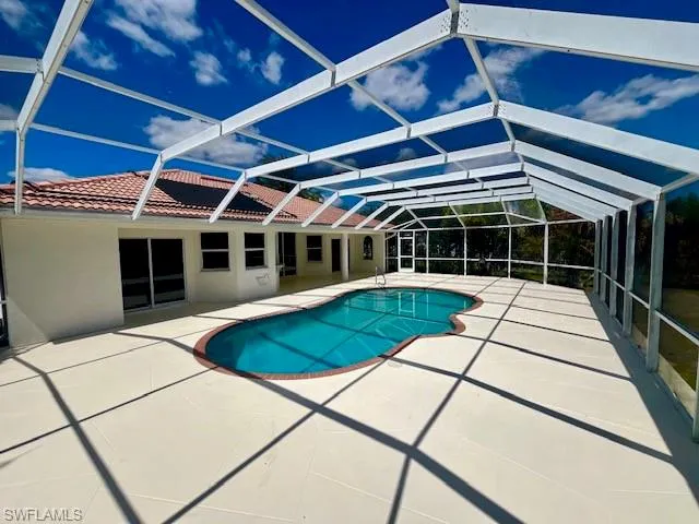 Outdoor pool with a sunroom, a patio, and a lanai