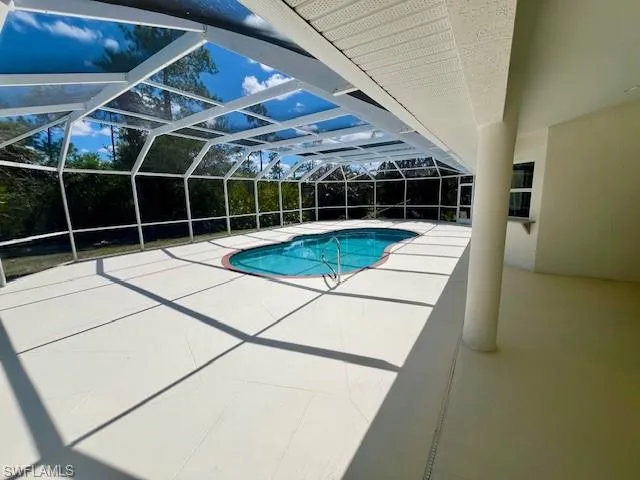 Swimming pool featuring a patio, enclosure, and a sunroom