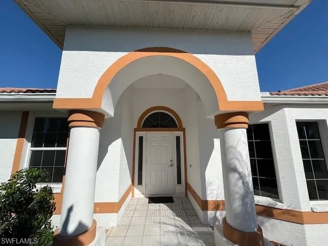 Property entrance with stucco siding and a tile roof