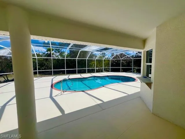 Outdoor pool featuring a patio, a lanai, and a sunroom