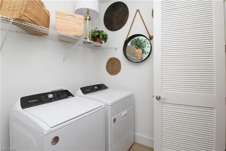 Laundry room featuring washer and clothes dryer and light wood-style flooring