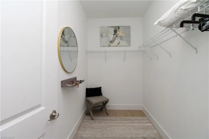 Walk in closet with light wood-type flooring