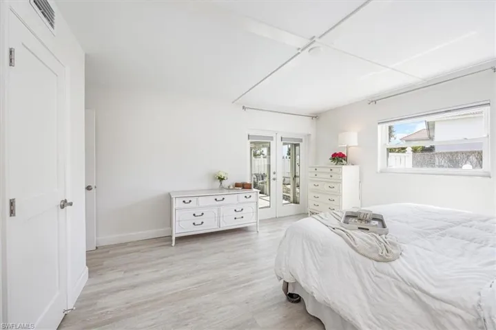 Primary bedroom with French door access to the screened, covered patio and private courtyard space