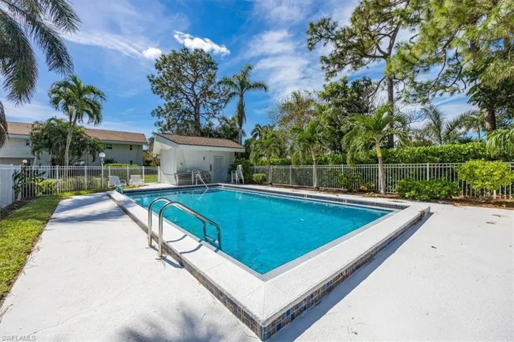 Community swimming pool with seating/lounging area and grilling area