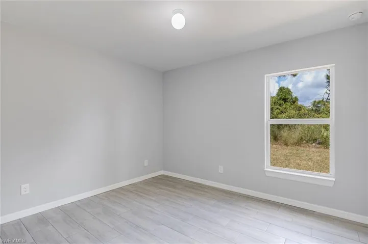 Spare room with baseboards and light wood-style floors