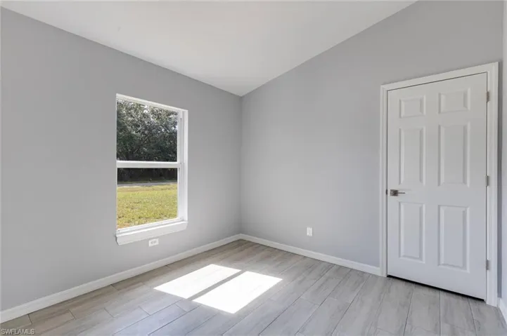 Empty room with baseboards and wood tiled floors